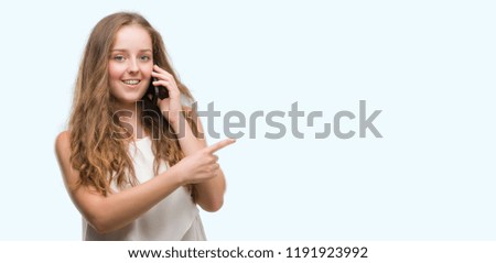 Young blonde woman using smartphone very happy pointing with hand and finger to the side