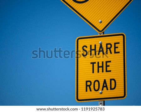 Yellow share the road sign on road side bicycle lane