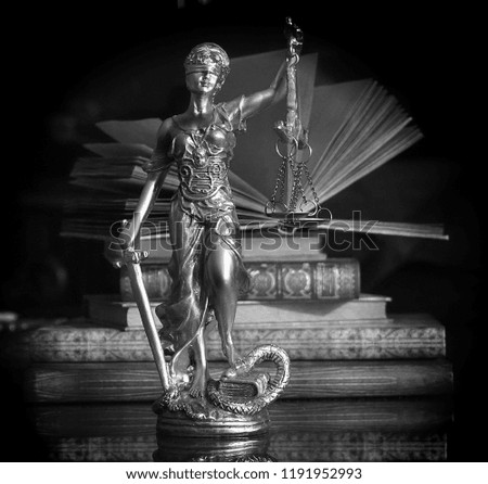 Statue of goddess of justice with old books - black and white