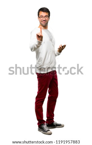 Full body of Man with glasses and listening music showing and lifting a finger in sign of the best on white background
