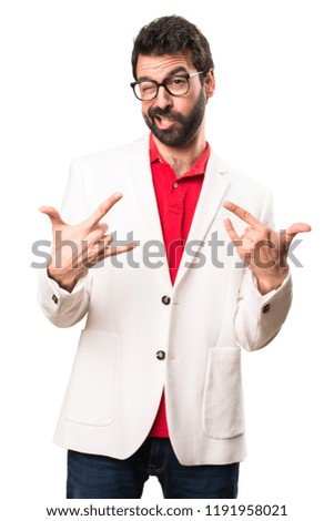 Brunette man with glasses making rock gesture on white background