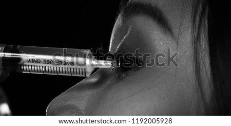 Black and White photography of woman put syringe medical into her eyes and drop water to both side, body part macro close up to head, asian young girl