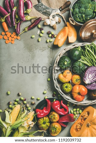 Healthy vegetarian seasonal Fall food cooking background. Flat-lay of Autumn vegetables over grey concrete background, top view, copy space, vertical composition. Vegan, alkaline diet food