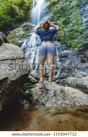 Woman standing and looking at Langganan Waterfall, Poring Ranau, Sabah.