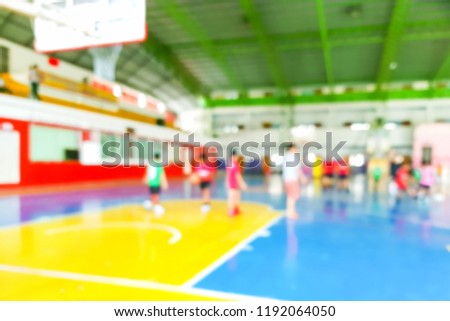 Blur images of children playing football and basketball in the gym.