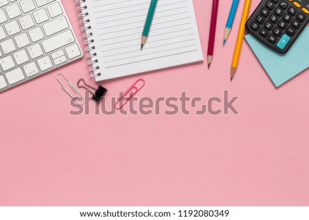 Top view office desk with smartphone, computer and office supplies on the desk pink background