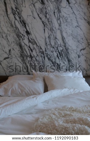 Cozy Bedroom scene with comfortable pillows and white wool blanket with natural white marble on the background / cozy interior concept / luxury design / interior design decoration