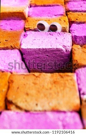 Googly eyes on stack of pink and orange bricks, Looking for fun concept