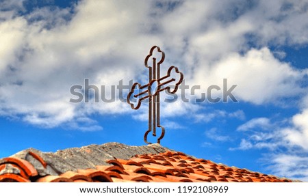 Metal cross on a tile roof
