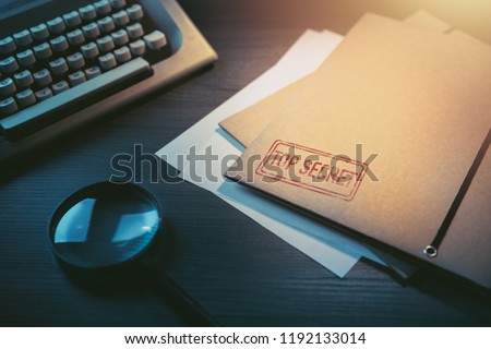 Private investigator desk with top secret envelopes Royalty-Free Stock Photo #1192133014