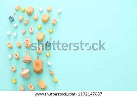 Image of jewish holiday Hanukkah with wooden dreidels colection (spinning top) over mint background