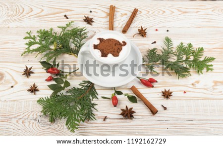 Macchiato or Latte Cappuccino on Rustic Wooden Background with 2019 New Year Pig Symbol and Aromatic Spices. Holiday Mockup with Hot Coffee Cup and Piggy Silhouette on Cream Milk Foam