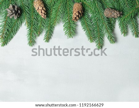 Christmas composition. Christmas tree branch, pine cones, fir branches on gray background. Flat lay, top view, copy space. Xmas frame