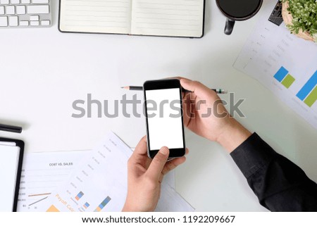Hands using mockup smartphone on business table.