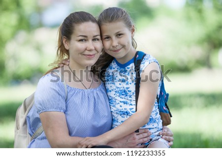 Portrait of two Caucasian people family with mother and her ten years old daughter, hugging and looking at camera