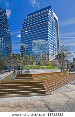 small urban park with fountain with skyscraper reflections
