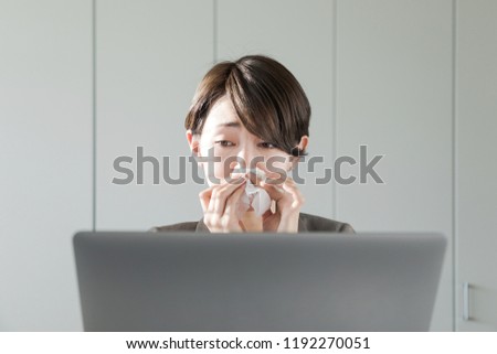 Young asian woman blowing her nose. Nasal inflammation. Hay fever. Royalty-Free Stock Photo #1192270051