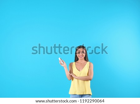 Young woman with air conditioner remote on color background