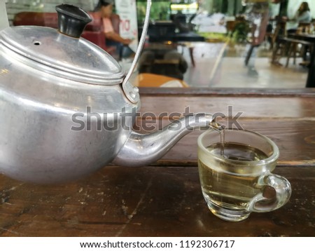 Man is pouring tea in glass.
