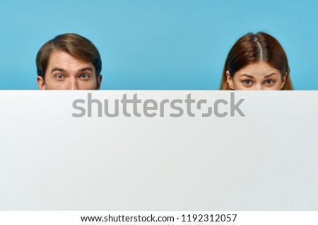 man and woman hid behind a white sheet of paper  mockup, poster                          