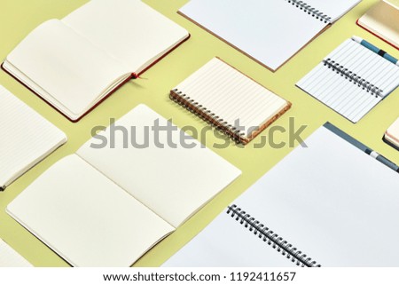 Many open notebooks with pages in yellow and white in light color background