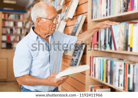 Modern senior man looking for books to read in his spare time in book store