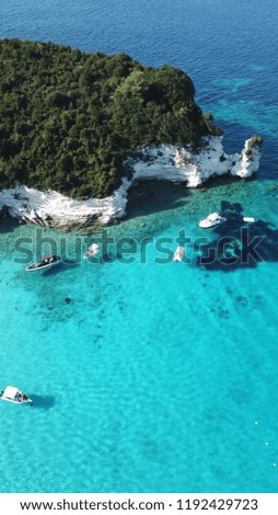 Aerial photo of exotic bay with sail boats and luxury yachts enjoying deep turquoise mediterranean sandy beach