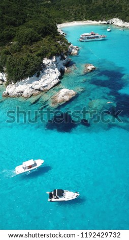 Aerial photo of exotic bay with sail boats and luxury yachts enjoying deep turquoise mediterranean sandy beach