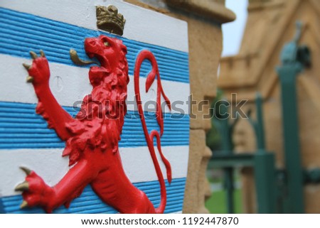 The civil ensign of Luxembourg, portrayed on a coat of arms, in Luxembourg City, Luxembourg.  Royalty-Free Stock Photo #1192447870