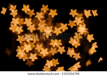 full frame of golden stars bokeh lights on black background