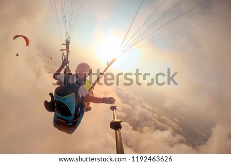 Paragliding in the sky. Paraglider tandem flying over the sea with blue water and mountains in bright sunny day. Aerial view of paraglider and Blue Lagoon in Oludeniz, Turkey. Extreme sport. Landscape Royalty-Free Stock Photo #1192463626