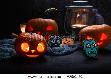 pumpkins with candles and skull cookies, halloween theme. dark background