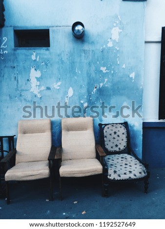 Three vintage chairs at blue wall background