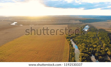 Flight in the beautiful countryside among a river of woods and fields near the city