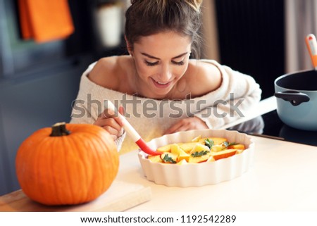 Picture of adult woman in the kitchen preparing pumpkin dishes for Halloween