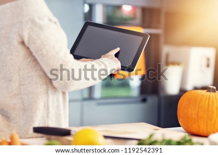 Picture of adult woman in the kitchen preparing pumpkin dishes for Halloween