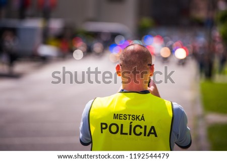 Policeman in jacket with tittle "Slovak Police" standing on the street.
