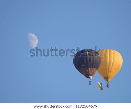 two balloons fly in the background of the moon