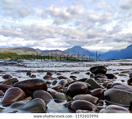 Rocky beach with mountains in the distance on a cloudy day