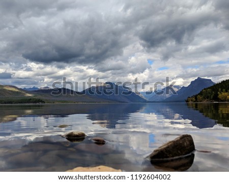 Calm lake with mountains in the distance on a cloudy day