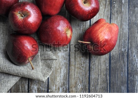 A group of fresh red apple on the wooden table with vintage sack