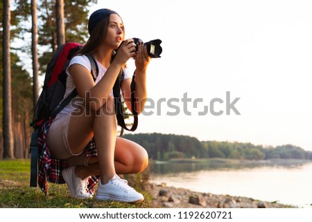 Nature Photographer taking pictures outdoors during hiking trip. Travel concept