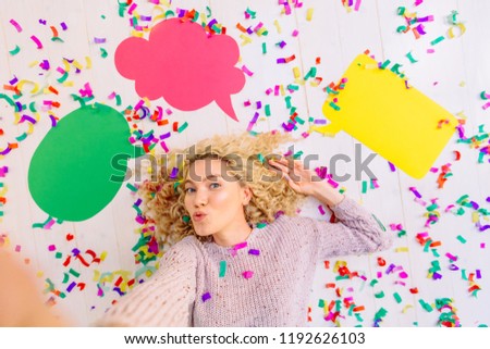 New idea. Curly blond excited woman lying with colorful confetti at the head of the new ideas in the form of three empty colorful bubbles for text, on white background. Seria with different emotions.