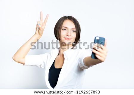 beautiful girl doing selfie photo and victory sign, short haircut, isolated over white background