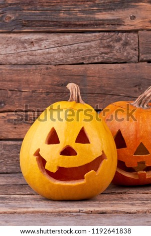 Funny pumpkins for Halloween holiday. Halloween pumpkins on vintage wooden background. Traditional vegetable of autumn holiday.