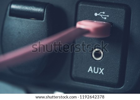 Detailed close up of a car usb port and auxiliary input with pink usb cable attached. Royalty-Free Stock Photo #1192642378