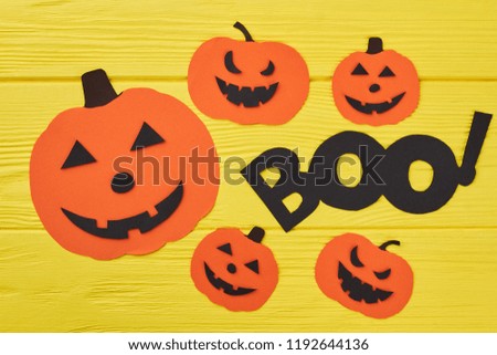 Halloween decorations background. Paper silhouette of different pumpkins on yellow background. Halloween holiday cutouts.