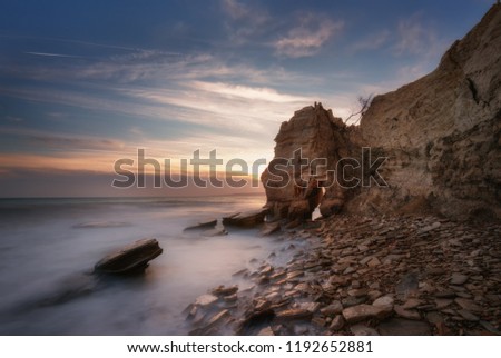 Seascape during sunset. Beautiful natural seascape, blue hour. Sea sunset at the Black sea coast near Balchik, Varna, Bulgaria. Magnificent sunset with clouds and rocks.