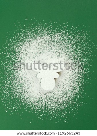 Head of a reindeer from sugar powder on green background