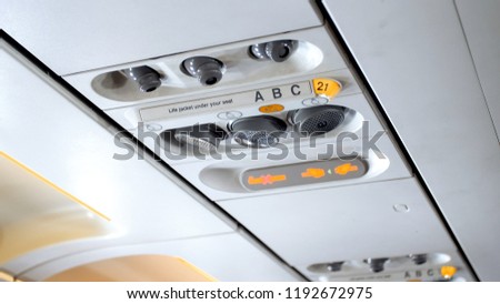Closeup image of buttons and lights on the ceiling above the pasenger seat in airplane